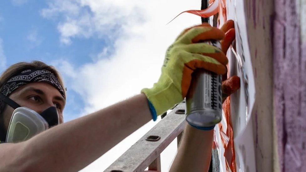 Deggy painting his mural of Vivienne Westwood in Glossop