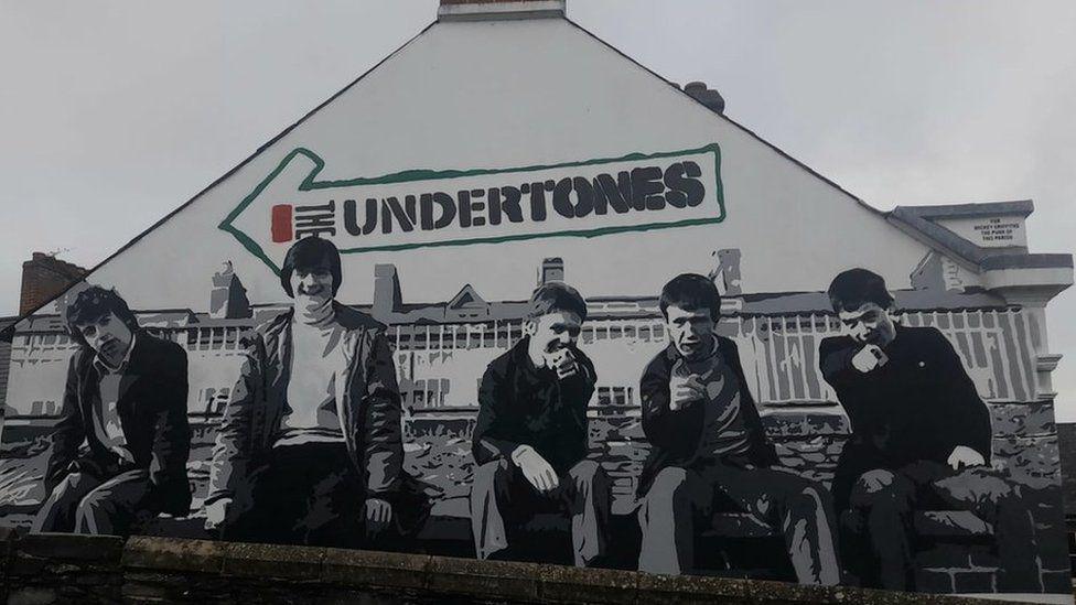 A mural of Derry punk band the Undertones, recreating their debut album cover, on a city centre gable wall