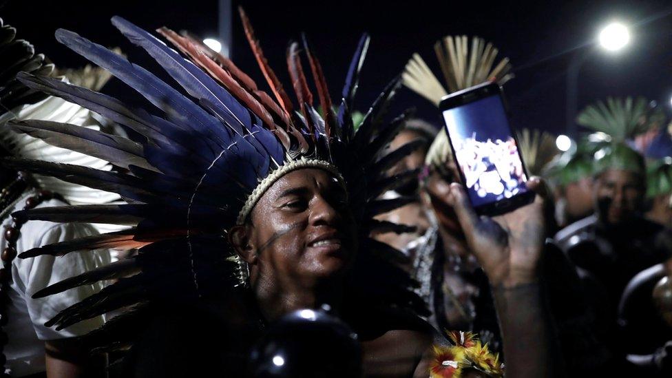 Indigenous men take part in a protest to defend indigenous land and cultural rights