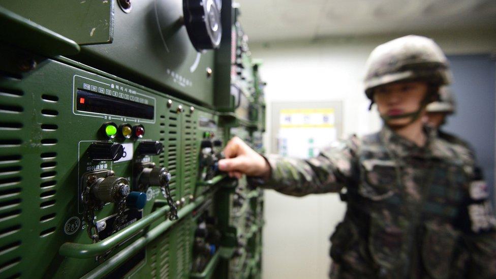 Soldier with his hand on controls for some of the speakers