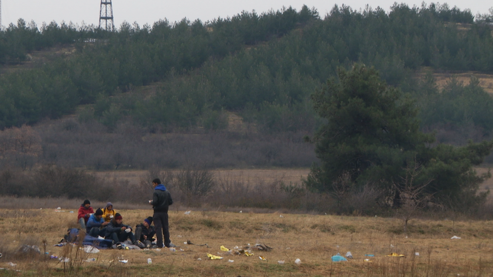 Migrant men sleeping outdoors, close to the woods