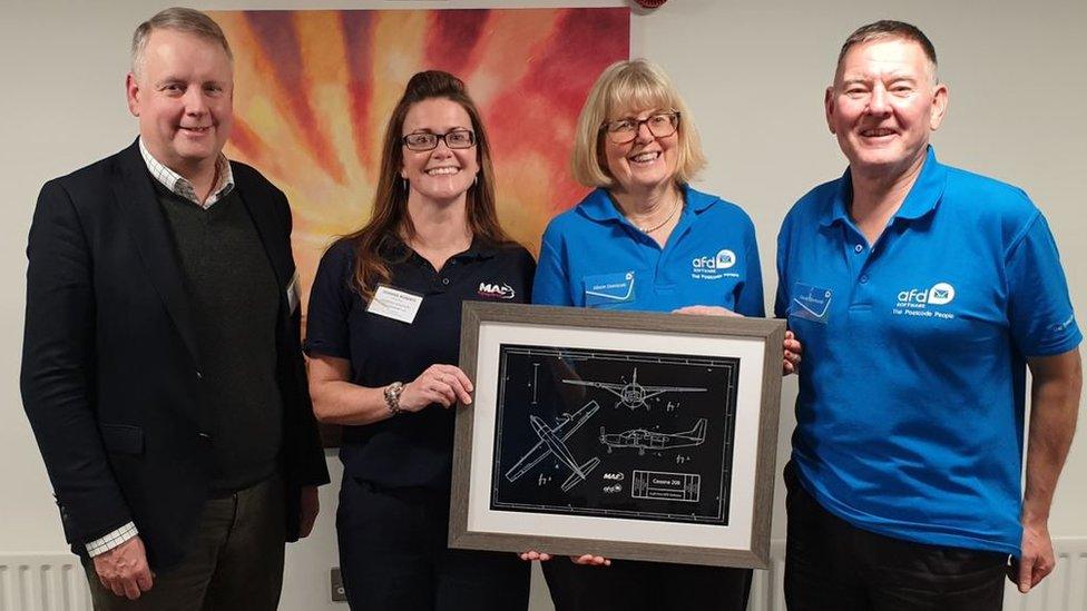 Members of MAF and AFD with a line drawing of the aircraft