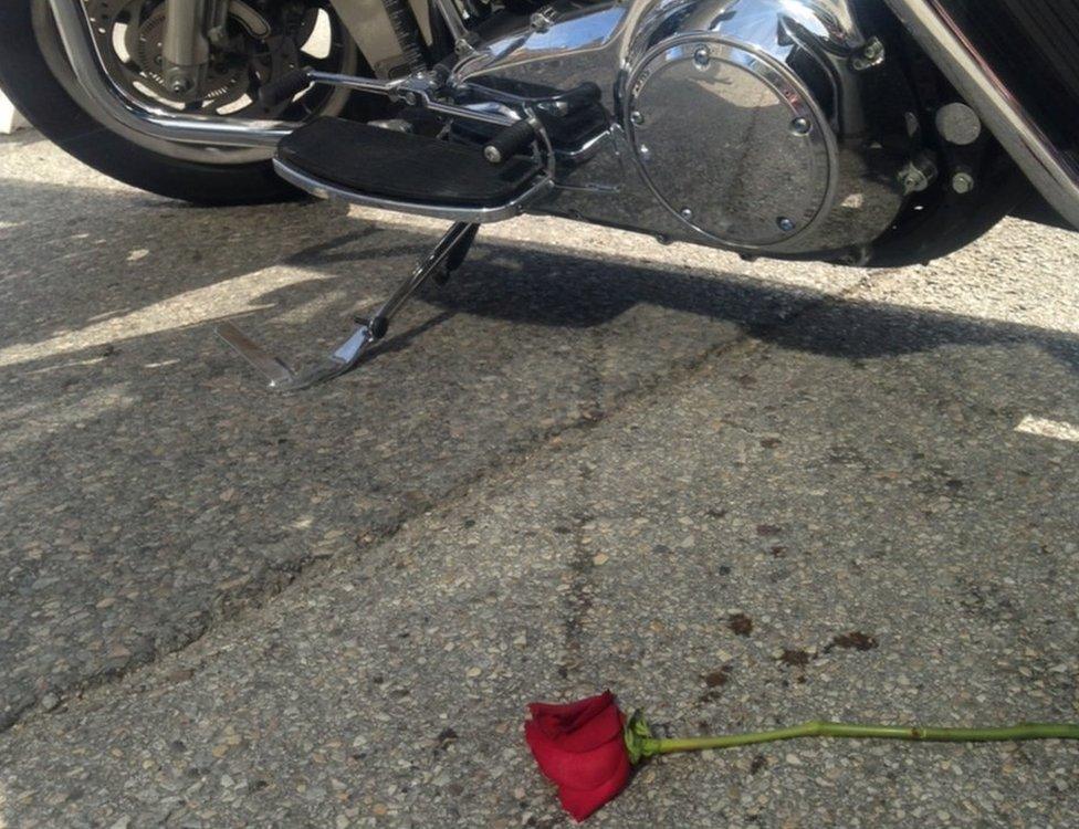 A rose lying next to a police motorcycle in Dallas