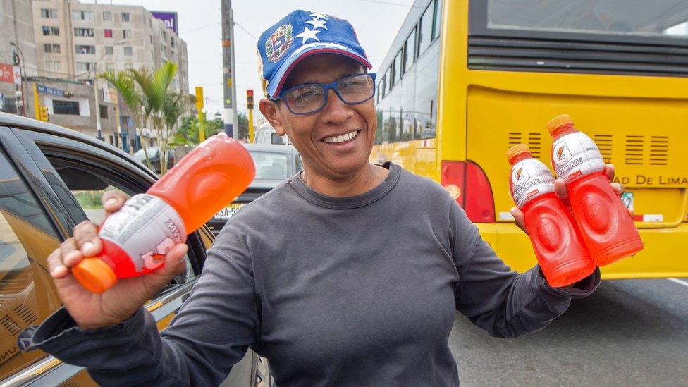 Venezuelan Mari Alvarez sells cold drinks while vehicles stop at a traffic light in Lima on April 4, 2019.