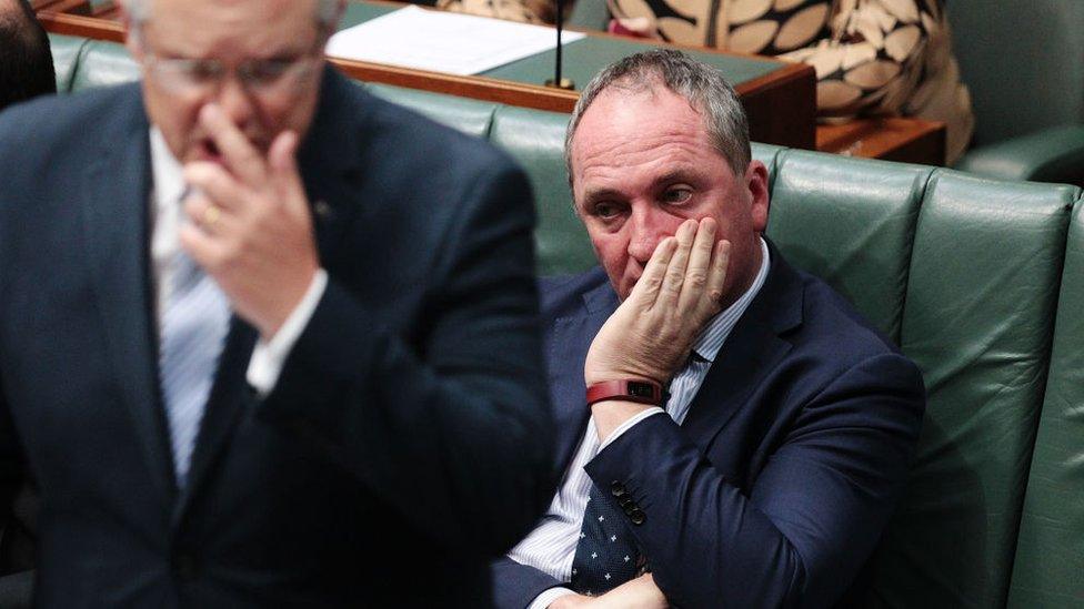 Barnaby Joyce holds his hand to his face while sitting in parliament