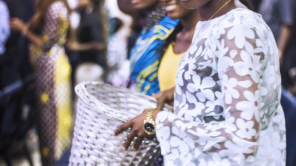 Congregation members pass around a collection basket for tithes and offering