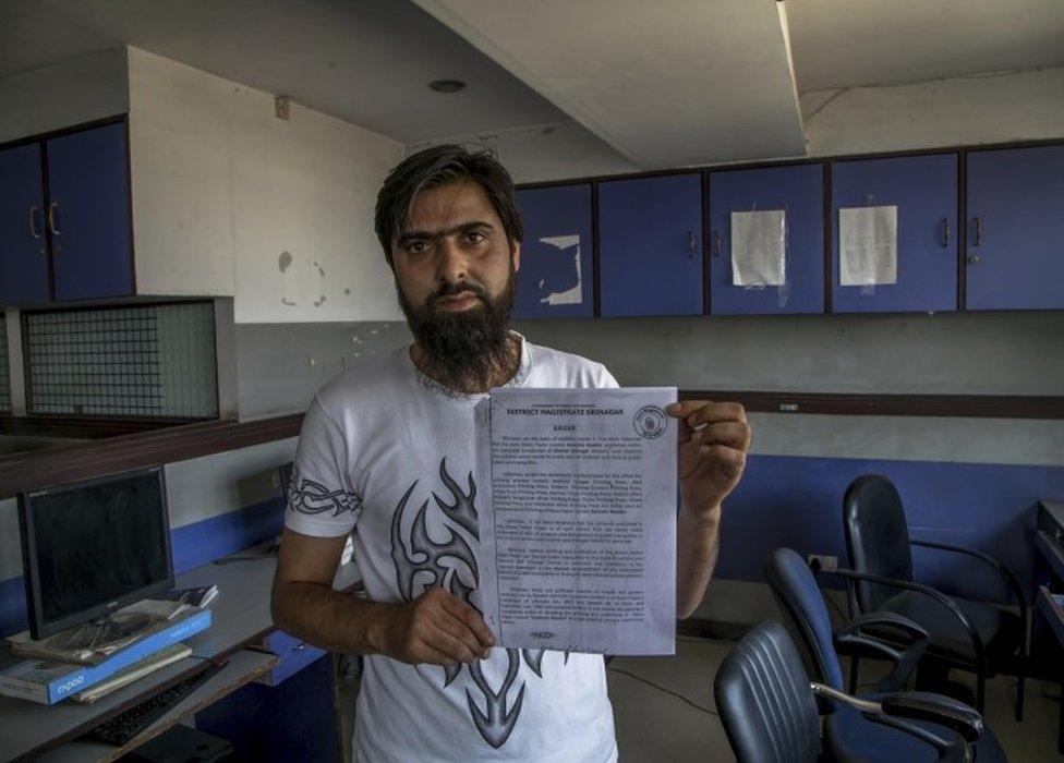 Feroz Ahmed, manager of "Kashmir Reader" newspaper shows a state government order in Srinagar, Indian controlled Kashmir, Tuesday, Oct. 4, 2016.