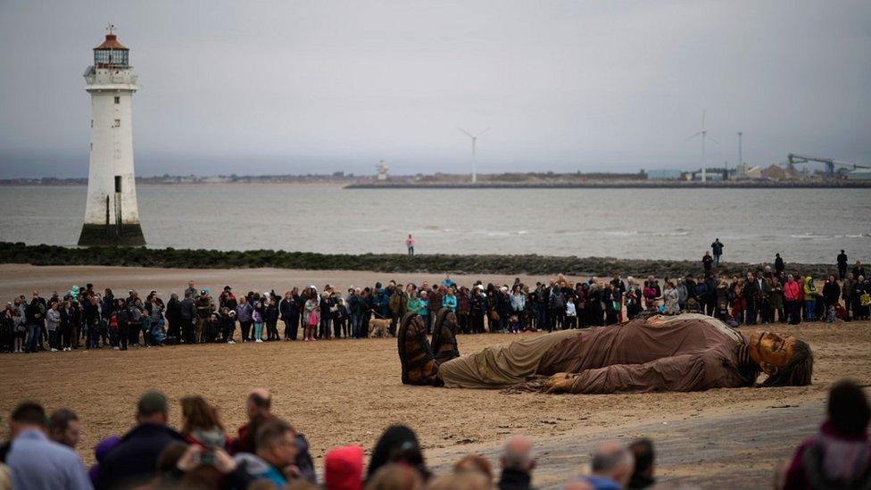 people watch big giant on beach