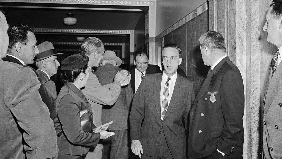 McCarthy and his lawyer Roy Cohn are applauded arriving at the Boston courthouse