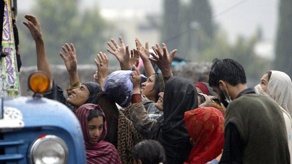 Kashmiri earthquake survivors receive relief goods from a truck in October 2005