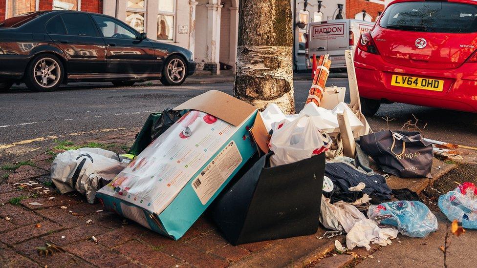 A pile of boxes and bags full of rubbish on the pavement of a Northampton street