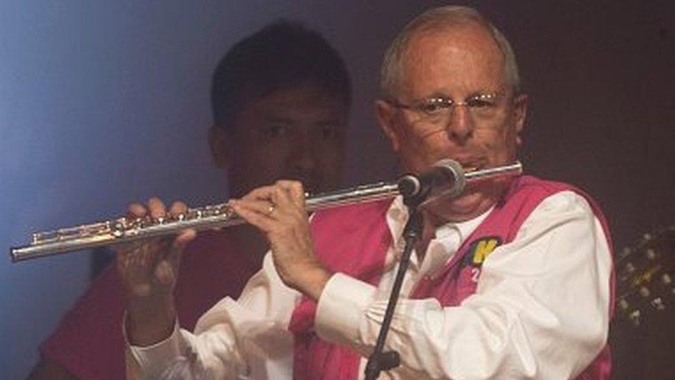 Presidential candidate Pedro Pablo Kuczynski of the 'Peruanos por el Kambio' political party, plays the flute during his closing presidential campaign rally in Lima on April 6, 2016.