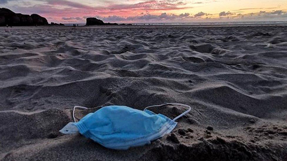 A discarded face mask on a beach