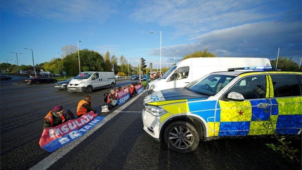 Police officers deal with protesters on major road