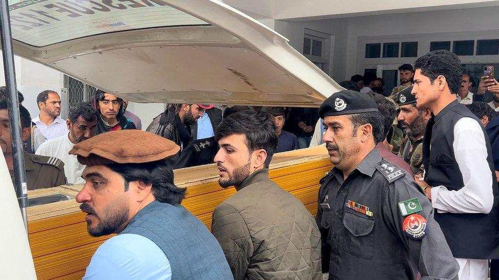 People carry a teacher's body into an ambulance after a school shooting in Kurram, Pakistan, on 4 May 2023