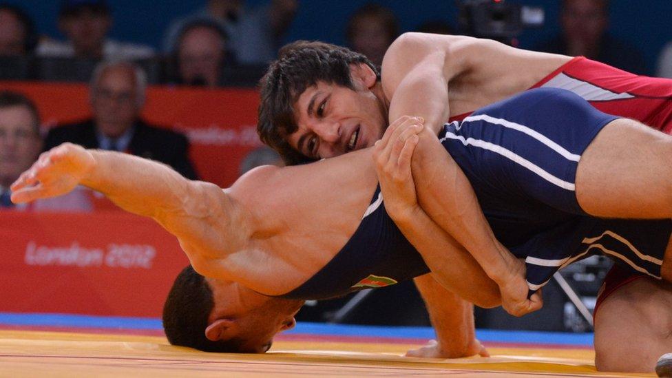 Iran'sHamid Mohammad Soryan Reihanpour (red) fights for the gold medal with Azerbaijan"s Rovshan Bayramov, speaks with a team member during their 55kg Greco Roman Wrestling semi-final match of the London 2012 Olympic Games