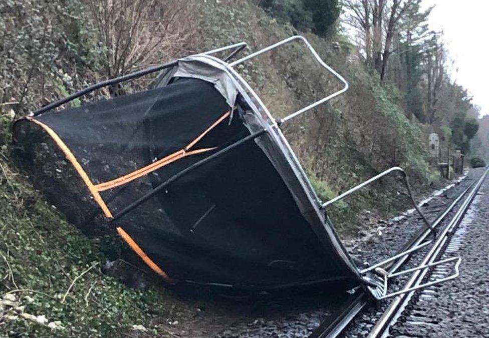 A trampoline blown onto the train line