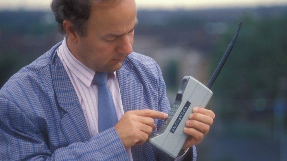 Man from 1980s using a mobile phone of the time