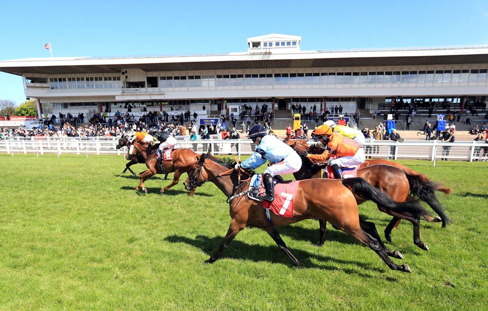 Racegoers watch the runners and riders during the Racing TV Straight Mile Fillies' Handicap at Redcar Racecourse.