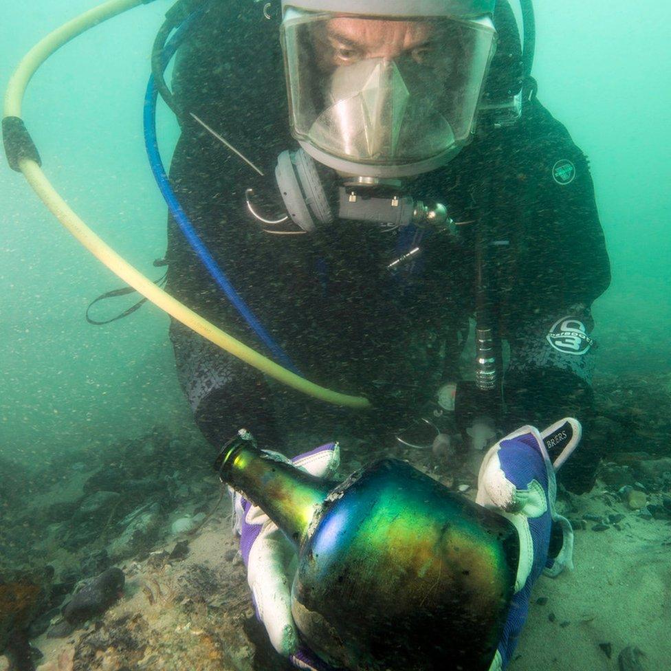 Diver with wine bottle from the ship