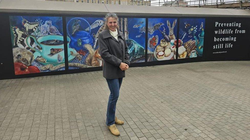 Cindy Powell standing in front of her mural