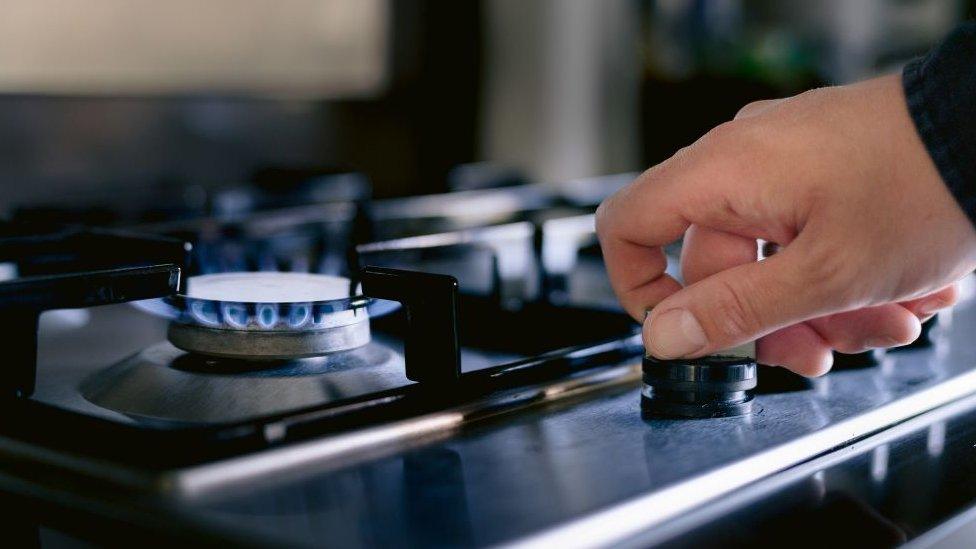 A man turns on a gas hob