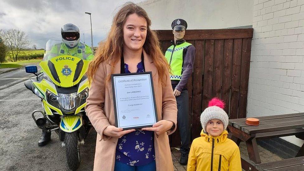 Erin Langdale next to mannequin holding her road safety hero certificate from Durham Constabulary