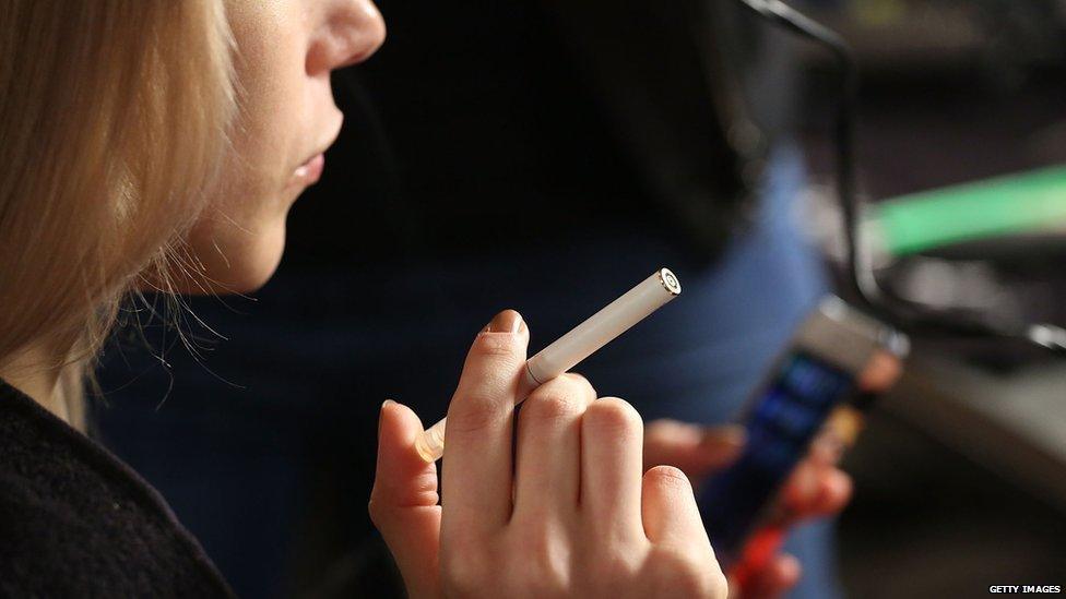 Model smoking e-cigarette in New York