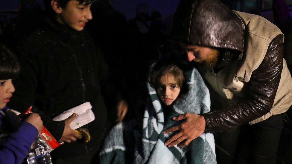 A girl is wrapped in a blanket after being evacuated from rebel-held Aleppo on 21 December 2016