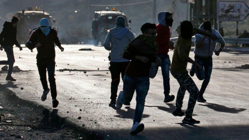 Palestinian protestors hurl stones towards Israeli security forces during clashes in the West Bank city of Nablus