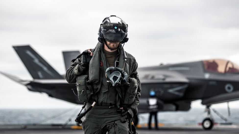 A pilot walks across HMS Queen Elizabeth's flight deck