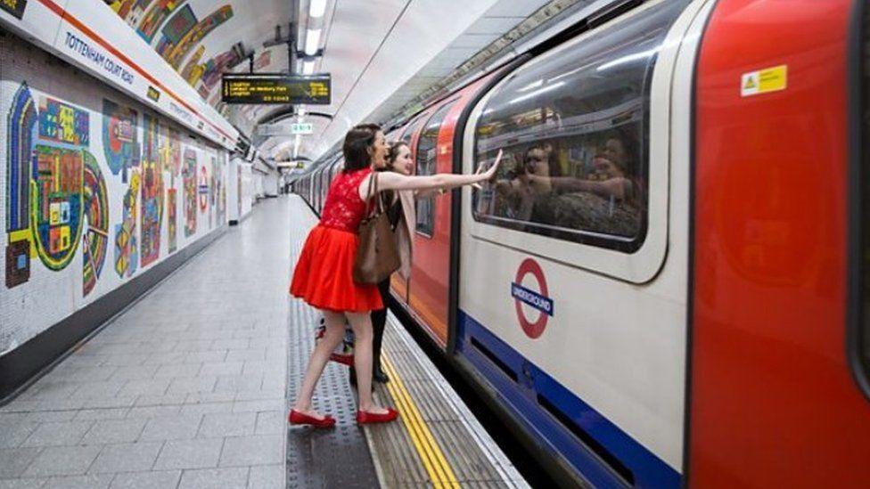 Woman wave through night tube window