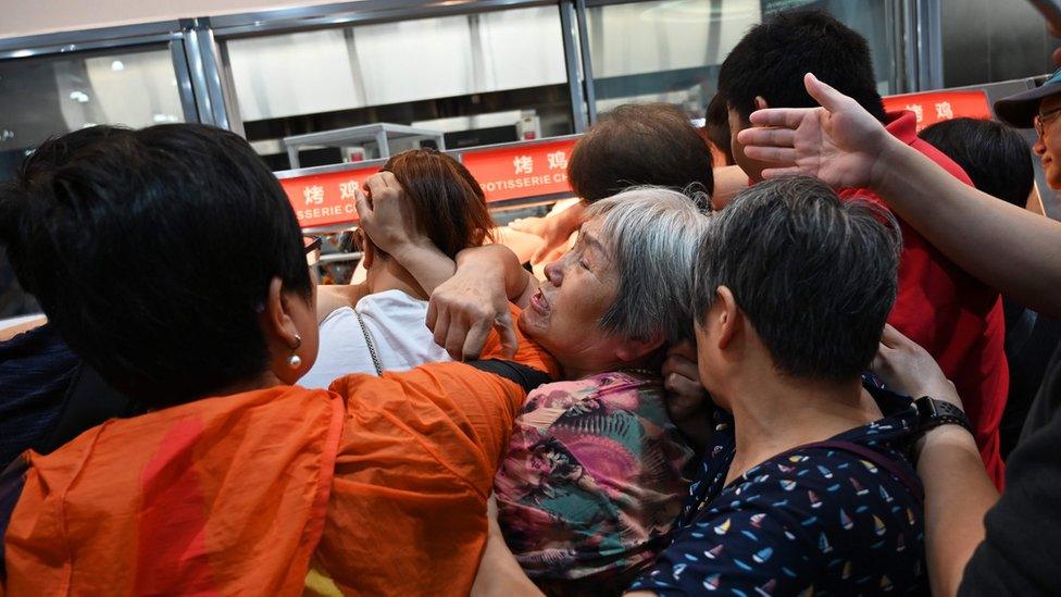 People jostle for cooked chickens