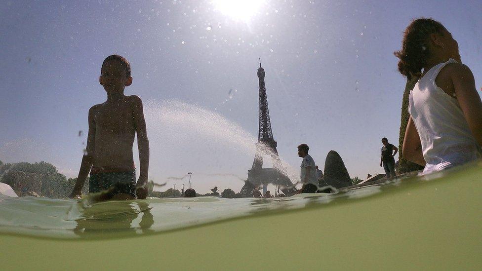 People cool off near to the Eiffel Tower in Paris