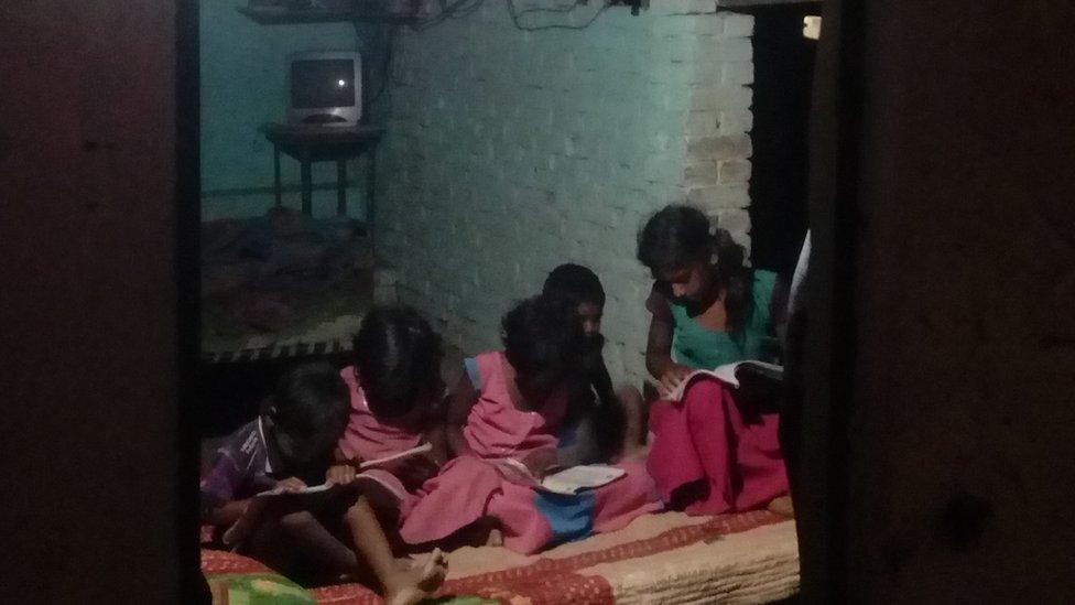 Children reading under a solar light