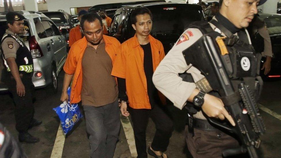 Suspected militants Aprimul Henry (left) and Ahmad Junaedi (right) are escorted by police officers as they arrive for their sentencing hearing at West Jakarta District Court in Jakarta, Indonesia (09 February 2016)