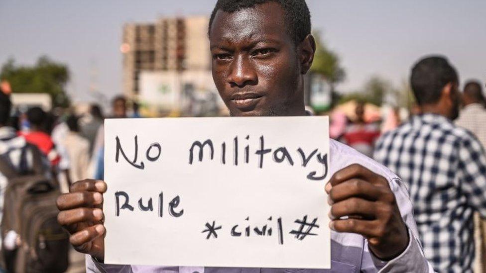 A Sudanese protester holds a placard during a sit-in outside the army headquarters in the capital Khartoum on 29 April 2019