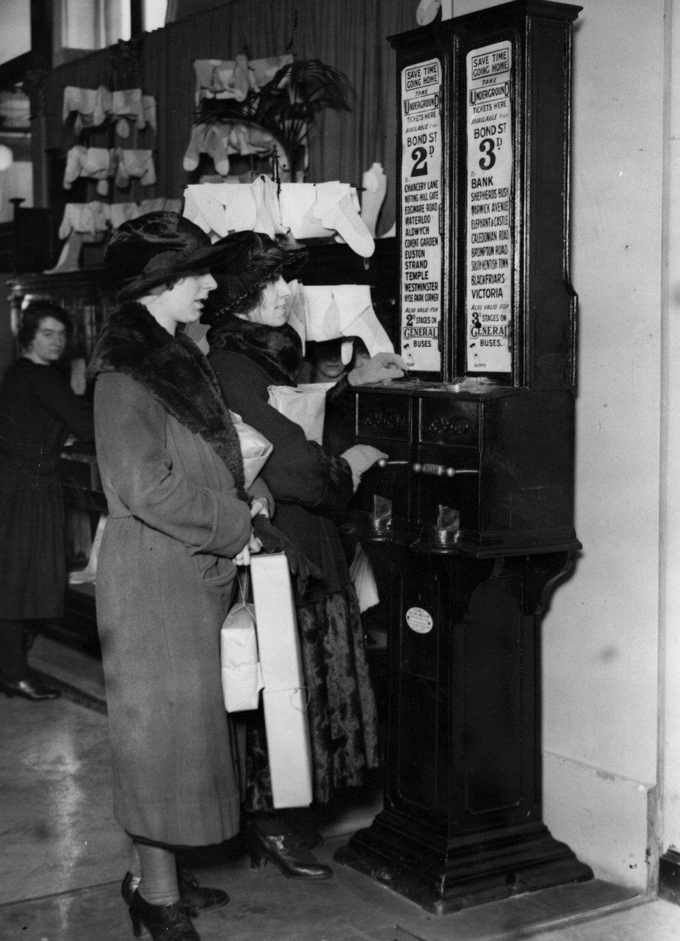 Women using an underground ticket machine located inside Selfridge's in 1923