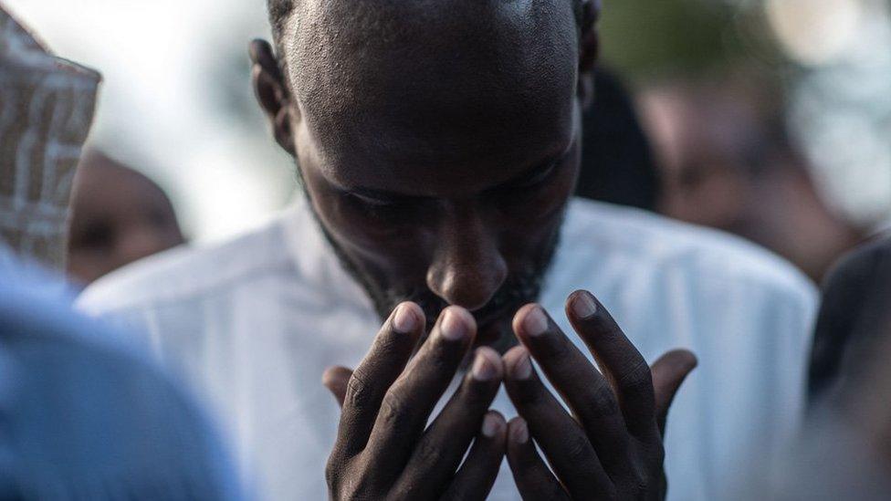 A man prays at the burial of Abdalla Mohamed Dahir and Feisal Ahmed on January 16, 2018