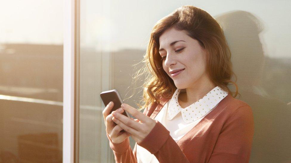 Young women reading info on her phone