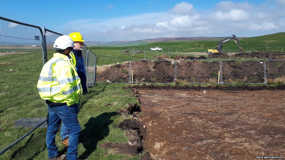 Two men inspect the site