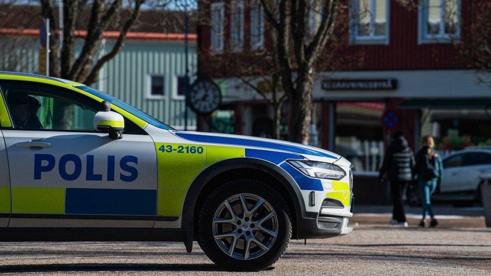 A police car is parked at a square