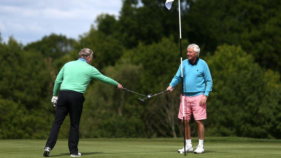 Golfers touch clubs at the end of a round