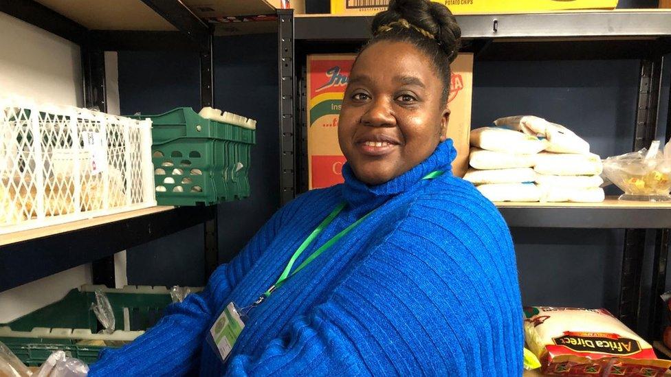 Volunteer Henriette Uiras working in the pantry, wearing a blue jumper