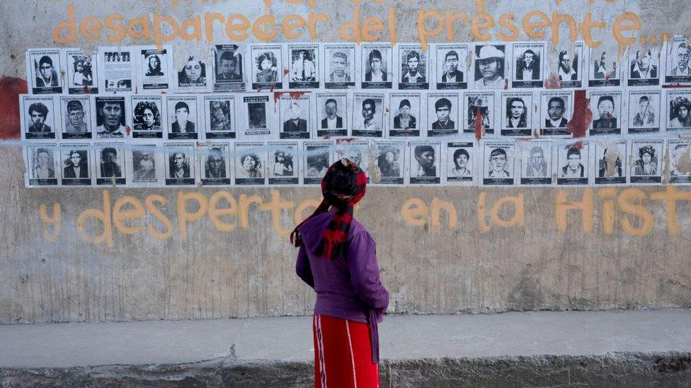 Woman looking at pictures of the disappeared