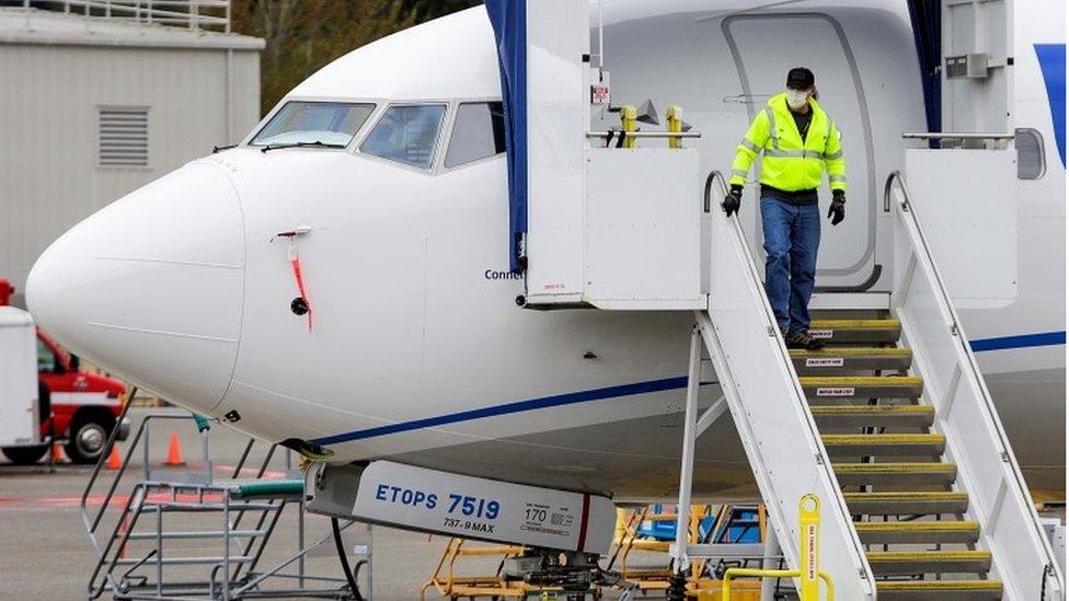 Boeing worker coming down steps of plane in facemask