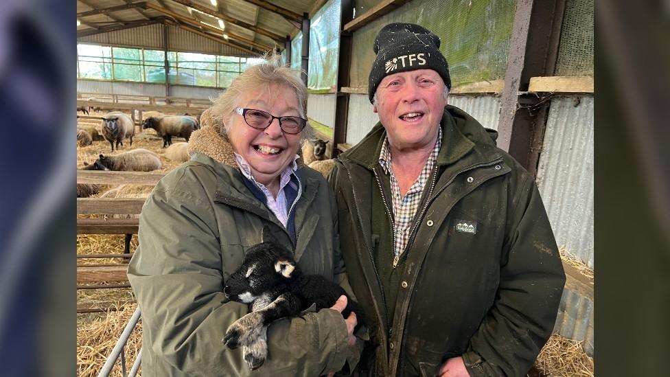 Sue and Aubrey Andrews and a lamb