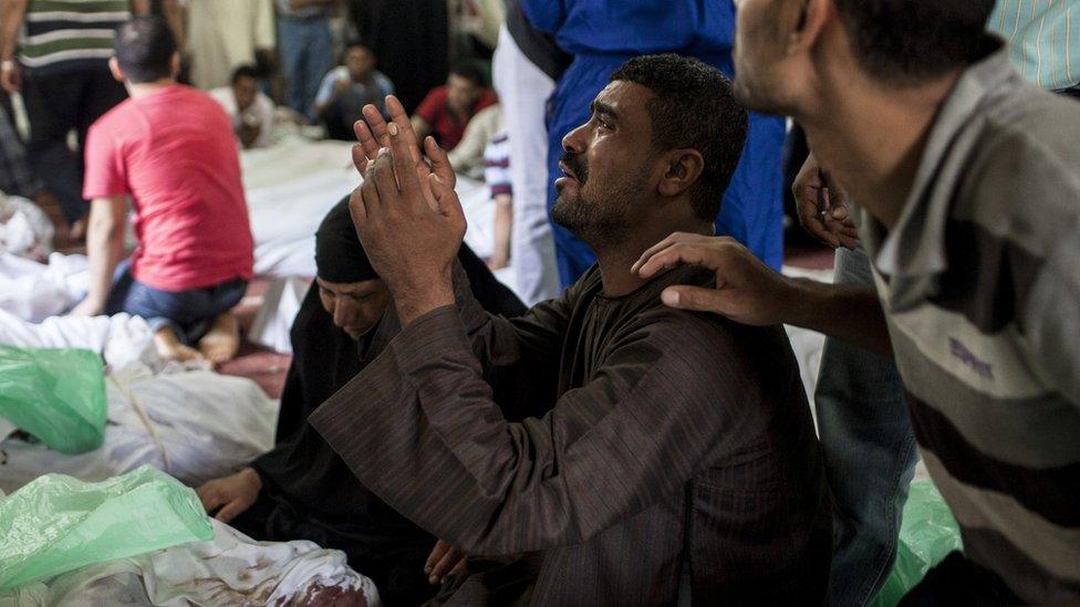 An Egyptian man identifies the body of a family member killed during a crackdown by Egyptian security forces in Cairo, Egypt (15 August 2013)