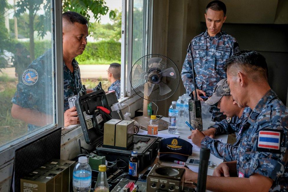 Thai air force officers make preparations for the helicopter at a helipad near Tham Luang cave