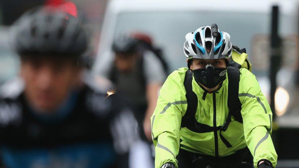 A cyclist wearing a breathing mask in central London